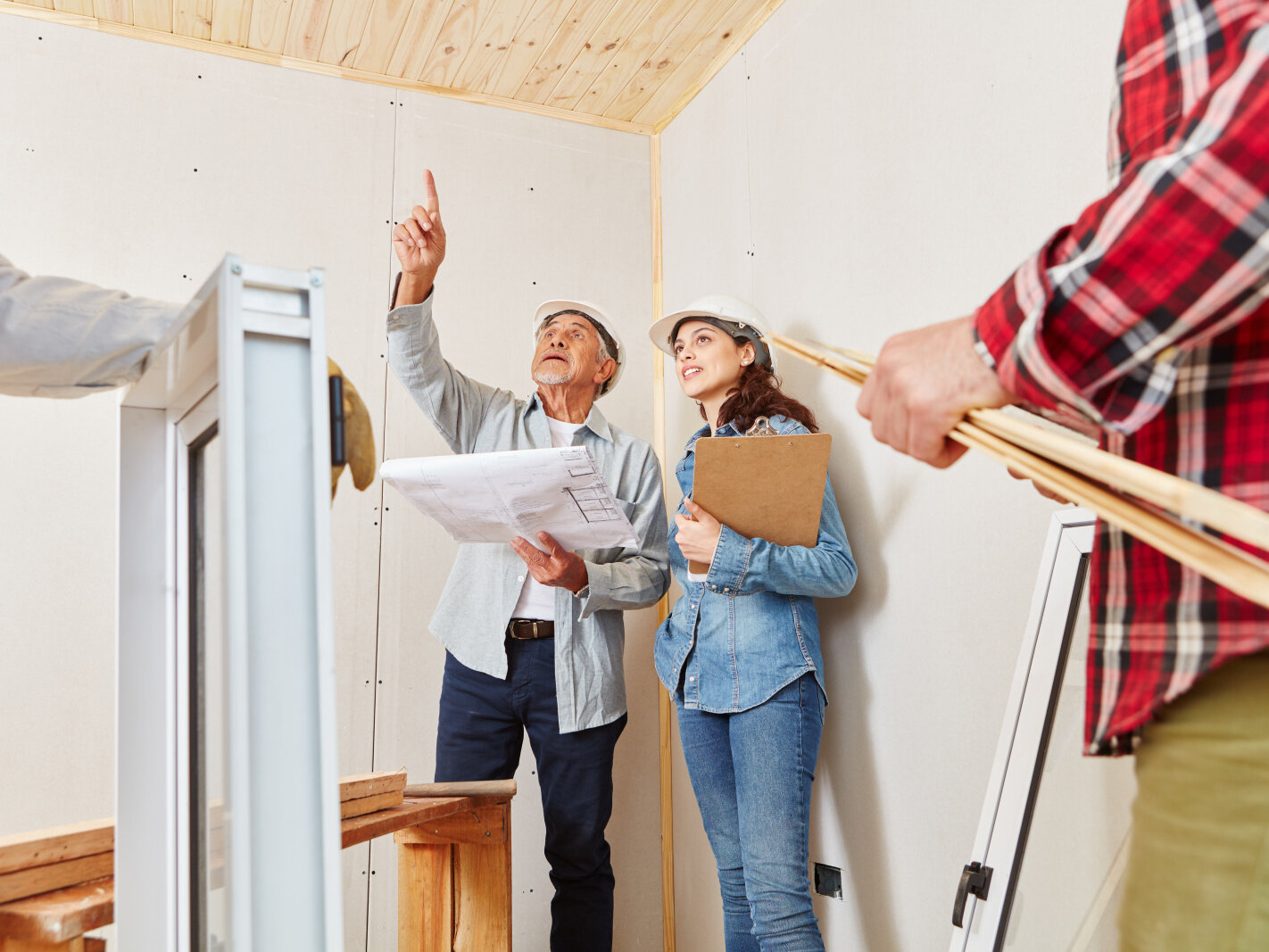 Examen de la liste de contrôle des travaux de rénovation et des plans architecturaux avec des experts sur place